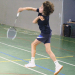 joueur de badminton en pleine action, venant de taper dans le volant