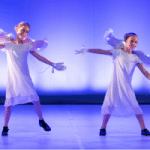 2 enfants sur scène déguisés en ange pour leur spectacle de claquettes