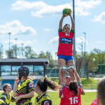 Equipe féminine de rugby dont une joueuse attrape le ballon en touche